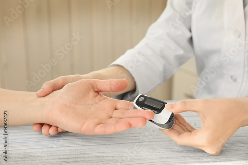 Closeup view of doctor examining woman with heart rate monitor