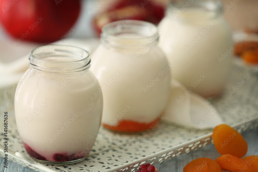 Glass jars with delicious yogurt on tray Glass jars with delicious yogurt on tray