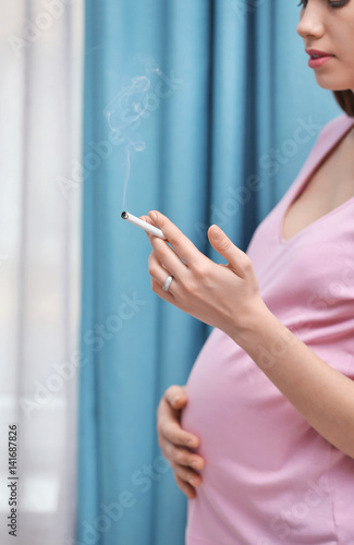 Pregnant woman smoking ciga...