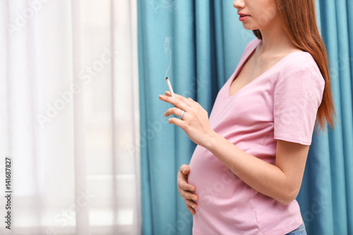 Pregnant woman smoking ciga...