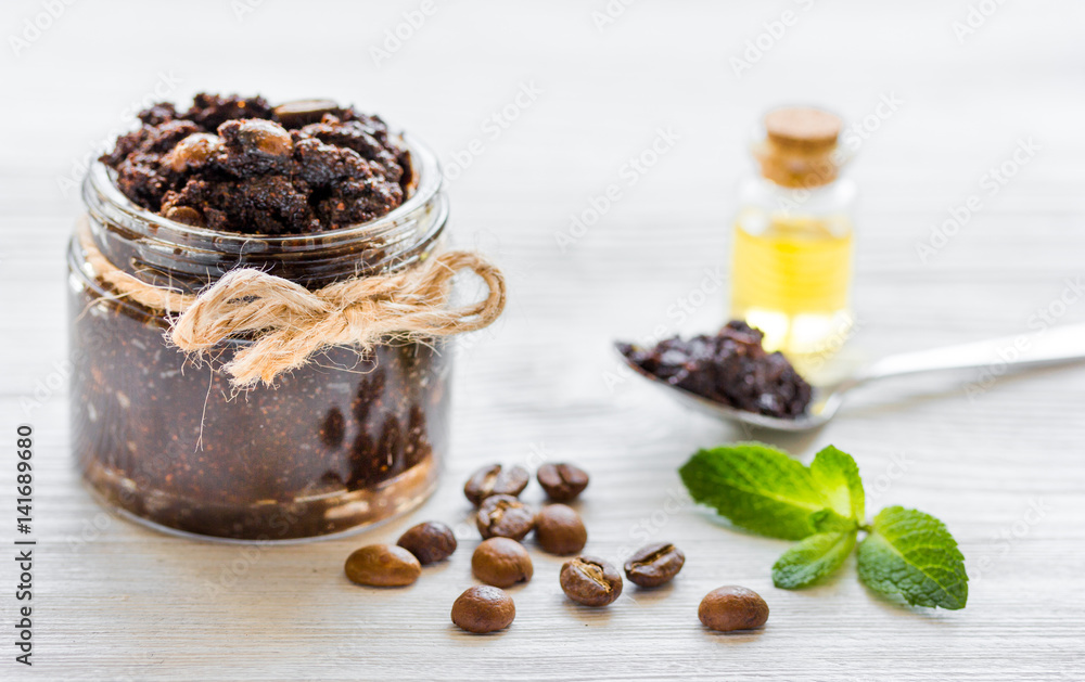 Body scrub of ground coffee with oil on white table background Body scrub of ground coffee with oil on white table background