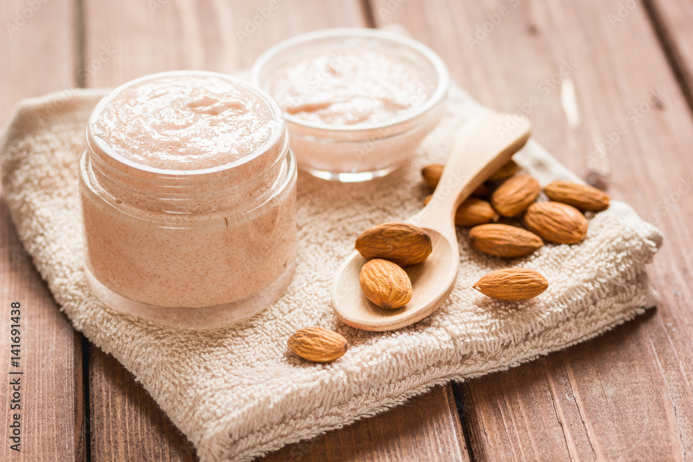 spa concept with almond nuts and scrub on wooden background spa concept with almond nuts and scrub on wooden background