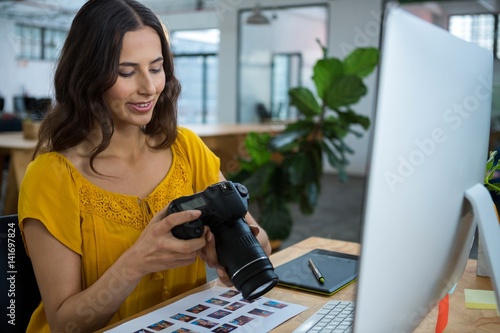 Photography Graphic designer looking at pictures in digital camera