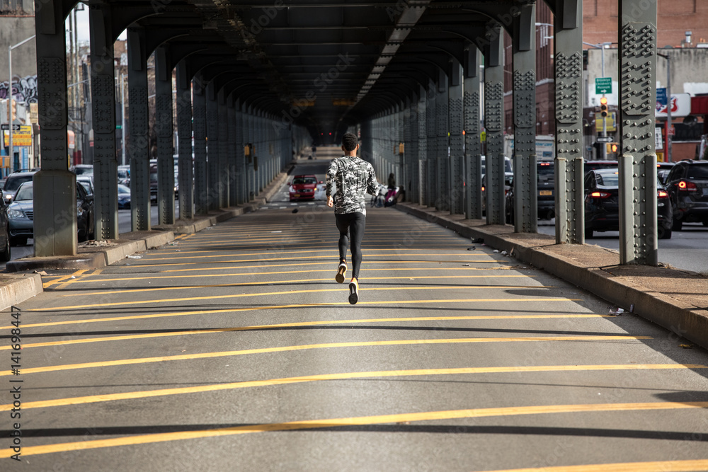 A young, black man goes for a jog in the streets of Brooklyn, NYC