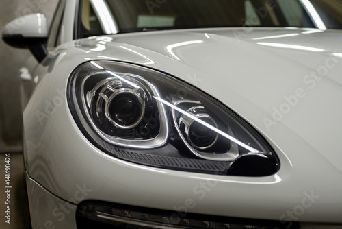 Auto headlights background. Car exterior detail. © alexdemeshko