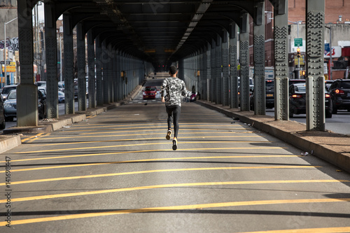 A young, black man goes for a jog in the streets of Brooklyn, NYC © Erik