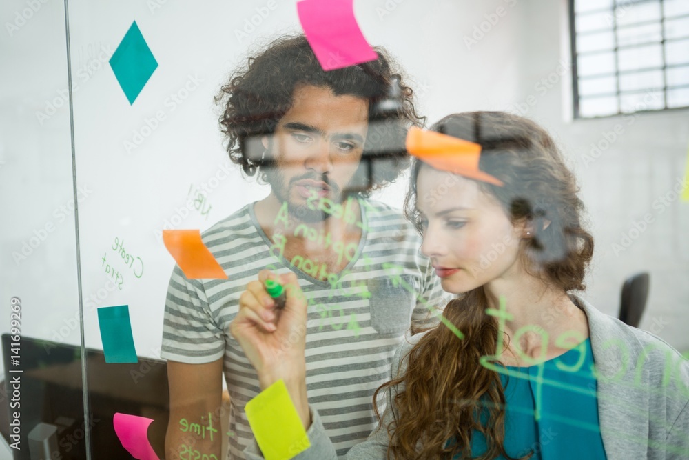 Executives writing on sticky notes Executives writing on sticky notes