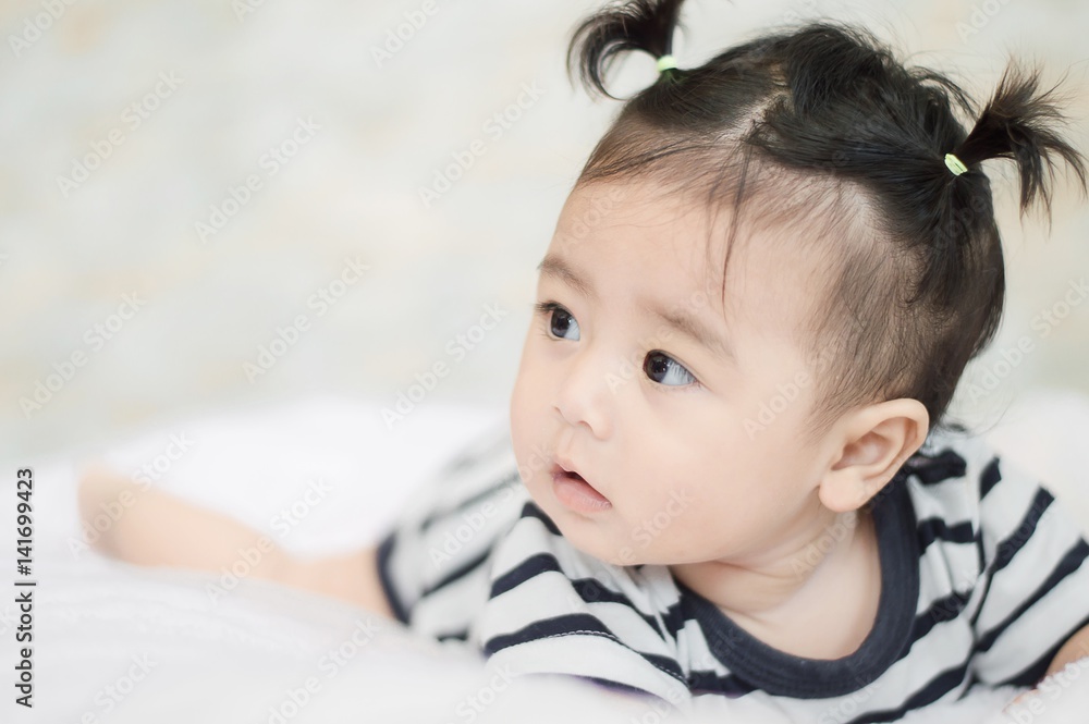 Portrait of cute baby girl in striped shirt on blanket of fur Portrait of cute baby girl in striped shirt on blanket of fur