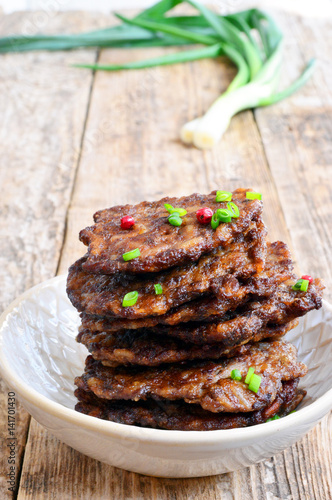 Fritters of liver. Pancakes from the liver. Food photo. Wooden background.