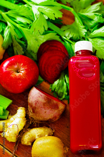 Bottles of delicious organic juice lying on desk sorrounded by fruits and veggies, beautiful colors, healthy lifestyle concept