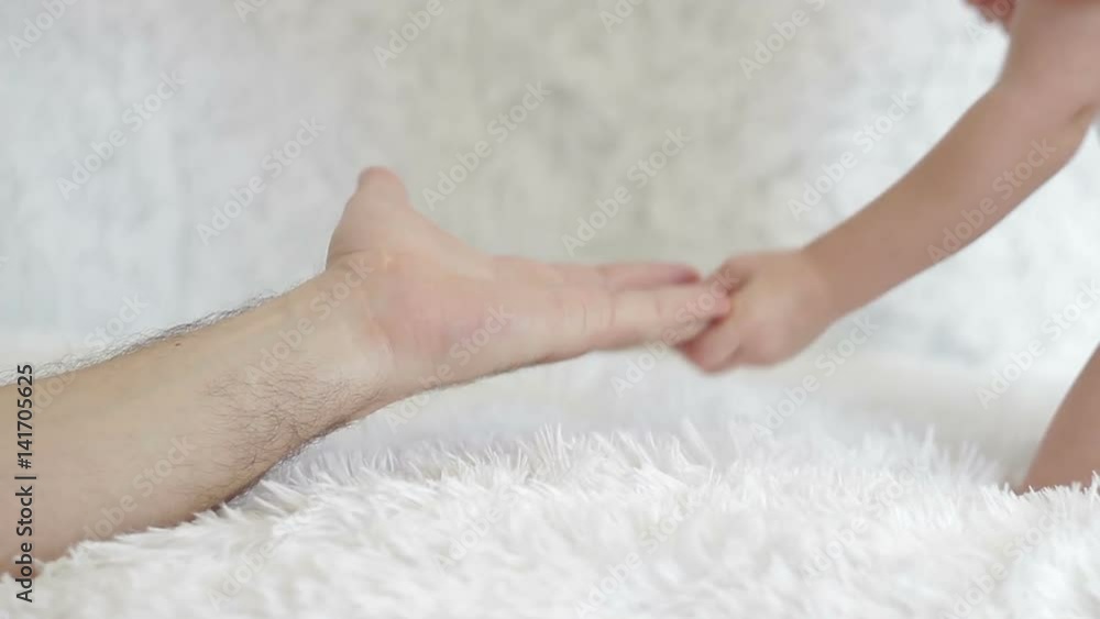 The child holds his father's hand. The child holds his father's hand.