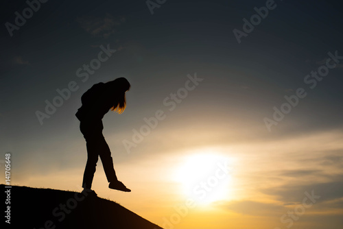 woman silhouette standing looking to sky at sunset