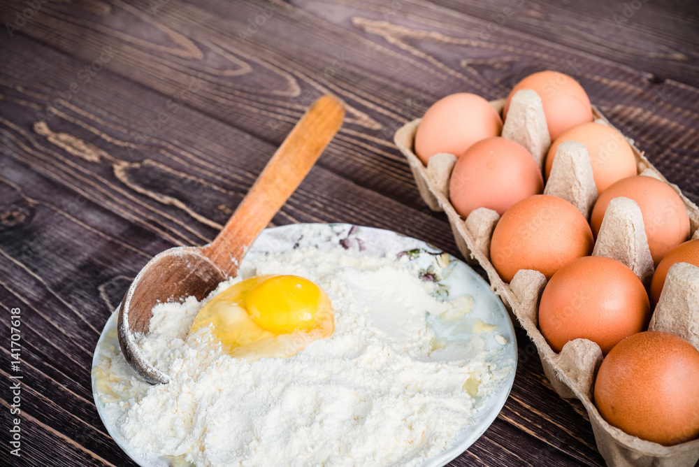 Eggs and flour on a wooden background, baking background Eggs and flour on a wooden background, baking background