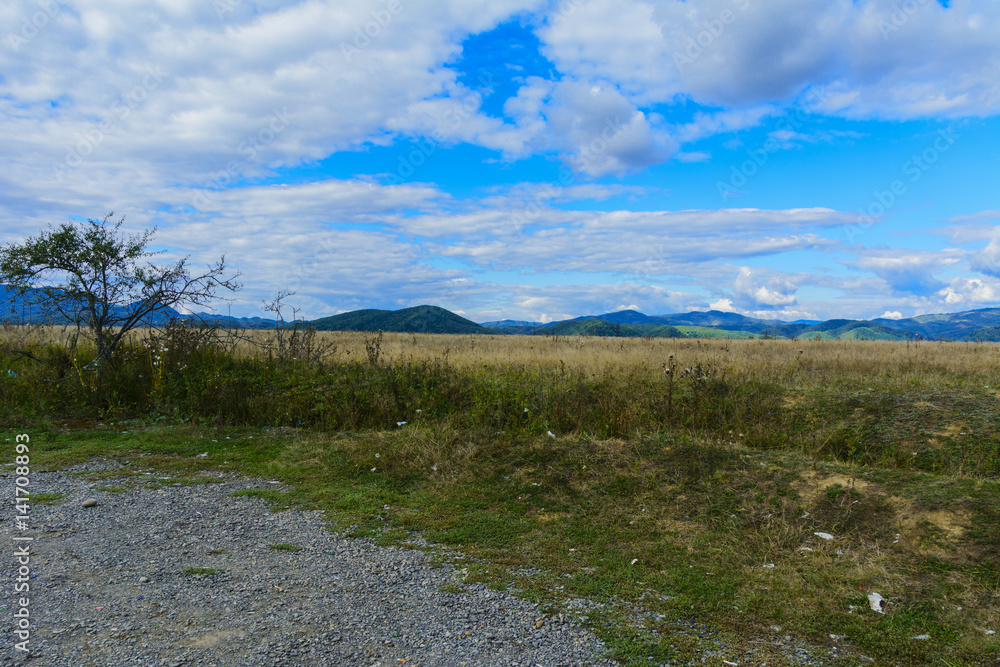 Mountain road. The landscape of fields and mountains Mountain road. The landscape of fields and mountains