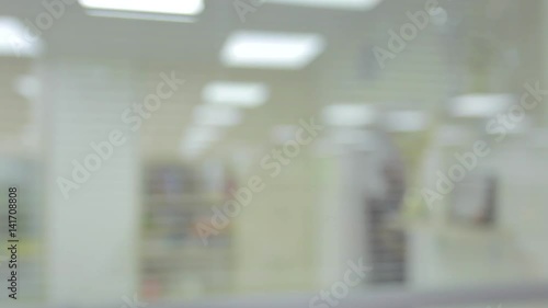 Blurred bright modern office, people walking, generic background. Intentionally defocused office