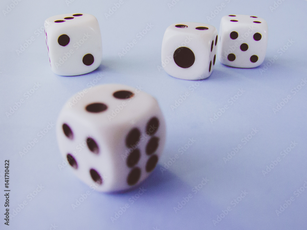 White cubic dices lying on a violet background. White cubic dices lying on a violet background.