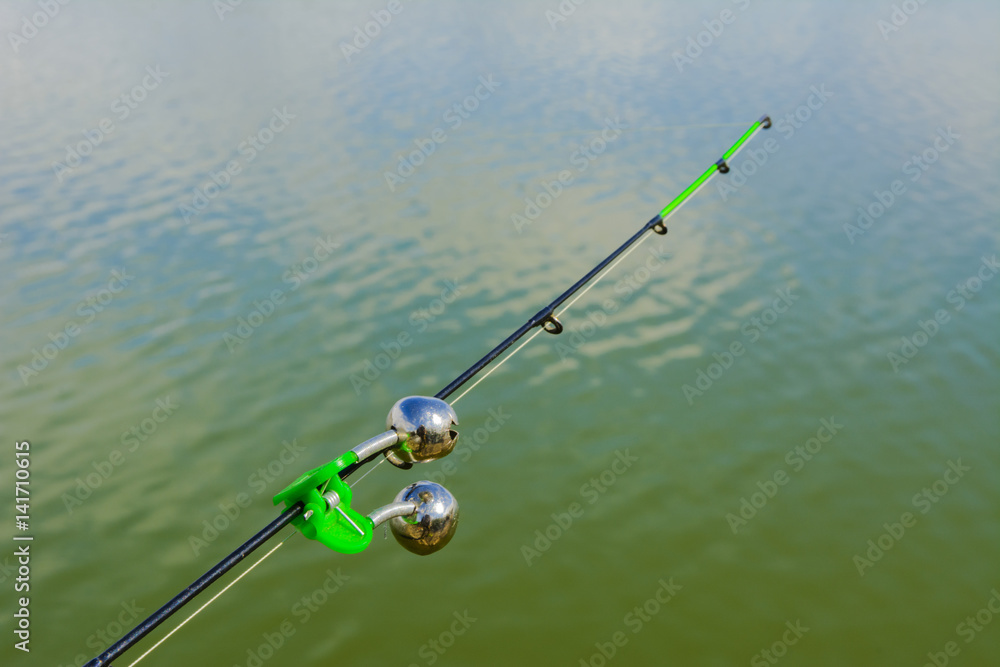 Lake in the mountains. Early morning. Fishing rod with a bell Lake in the mountains. Early morning. Fishing rod with a bell