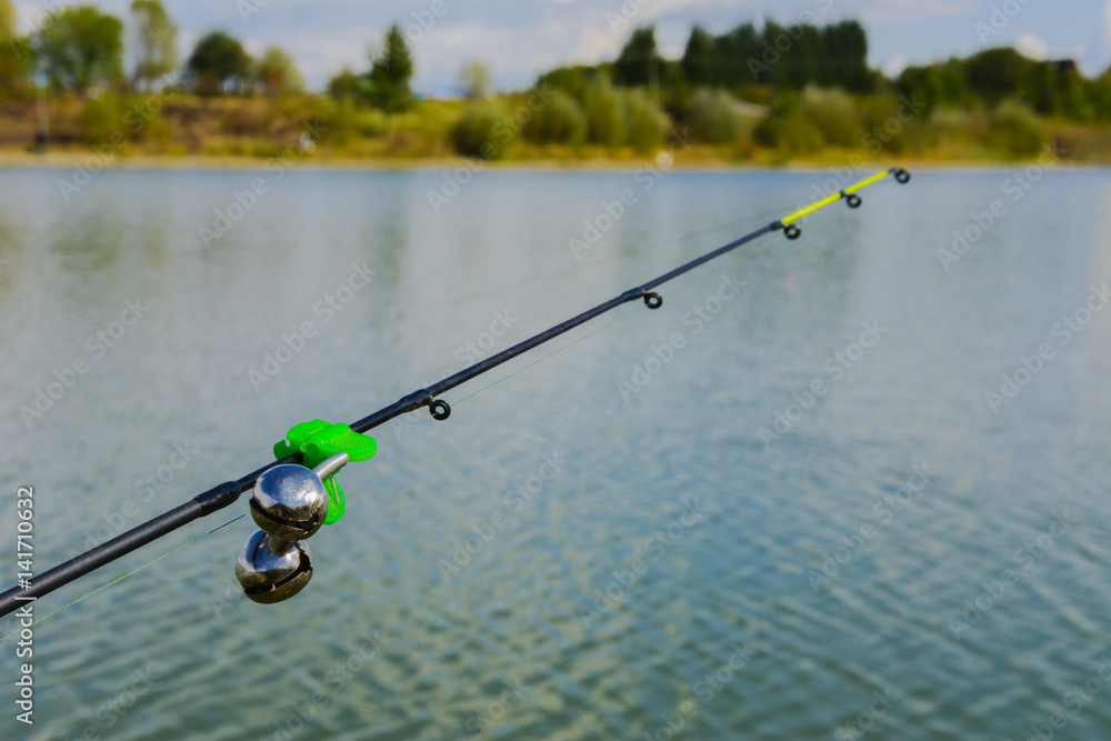 Lake in the mountains. Early morning. Fishing rod with a bell Lake in the mountains. Early morning. Fishing rod with a bell