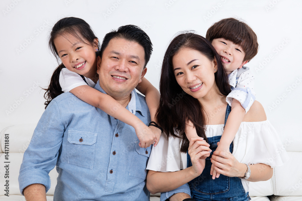 Happy Asian Chinese family sitting on the couch smiling Happy Asian Chinese family sitting on the couch smiling