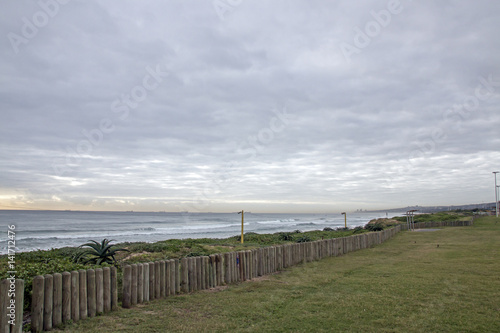 Green Lawn and Wooden Pole Barrier Fence on Beachfront