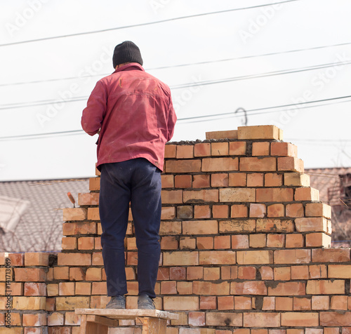 Wallpaper Mural Worker builds a brick wall in the house Torontodigital.ca