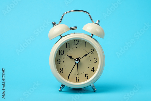 vintage alarm clock isolated on light blue background color