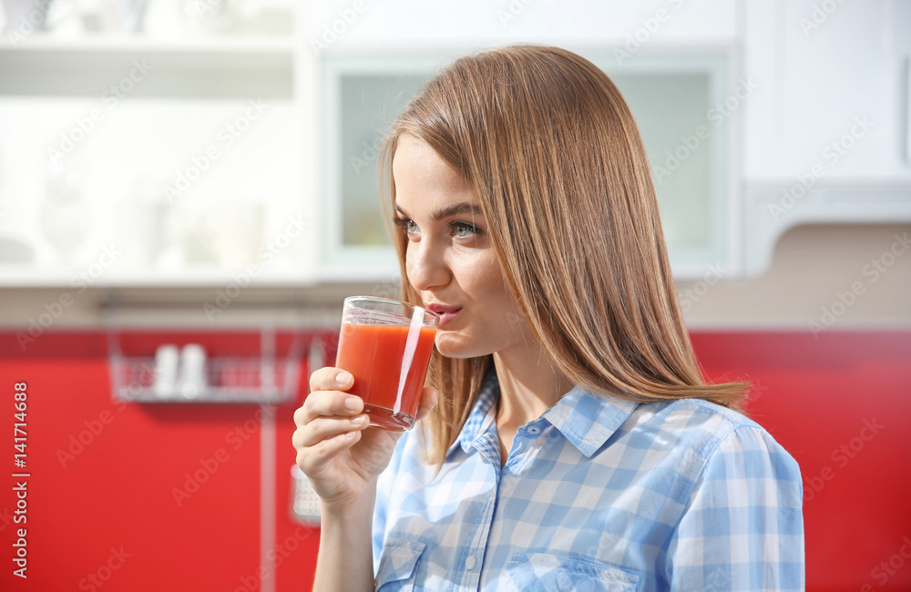 Young beautiful woman with fresh juice in the kitchen Young beautiful woman with fresh juice in the kitchen