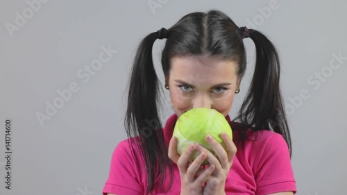 Beautiful young woman holding cabbage. Healthy food selection concept