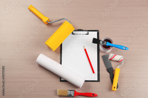 Foto Clipboard and decorator instruments on wooden table