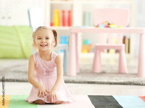 Cute little girl sitting on...