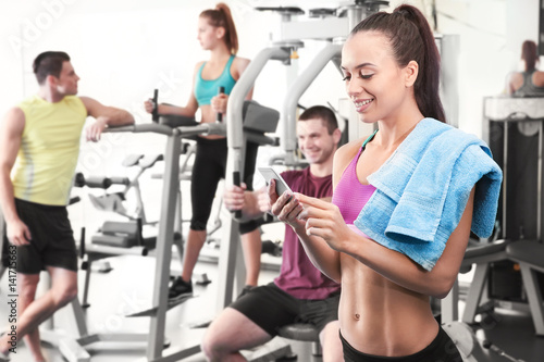 Young woman with cellphone in gym