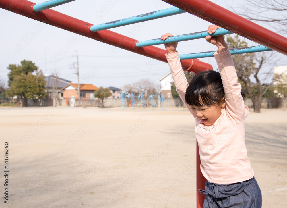 Fototapeta premium うんていをする女の子