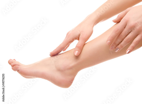 Leg and hands of young woman on white background
