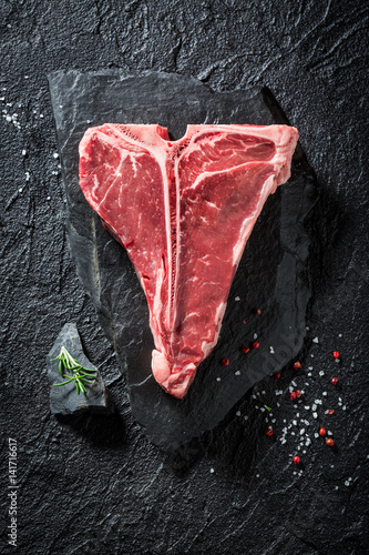 Fresh t-bone steak with salt, pepper and rosemary