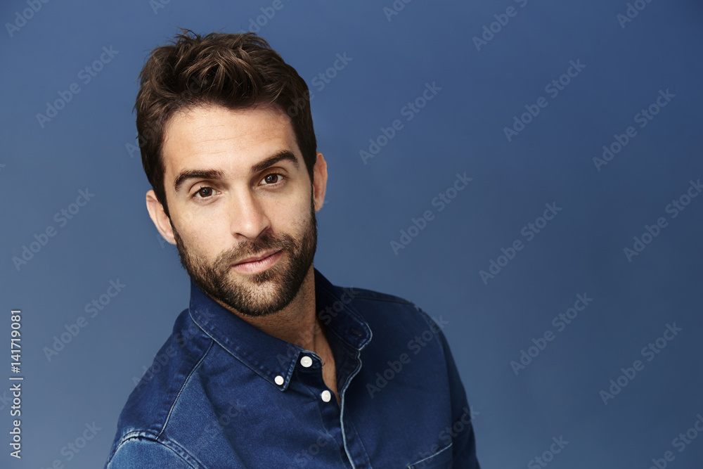 Obraz premium Brown eyed guy in blue studio, portrait