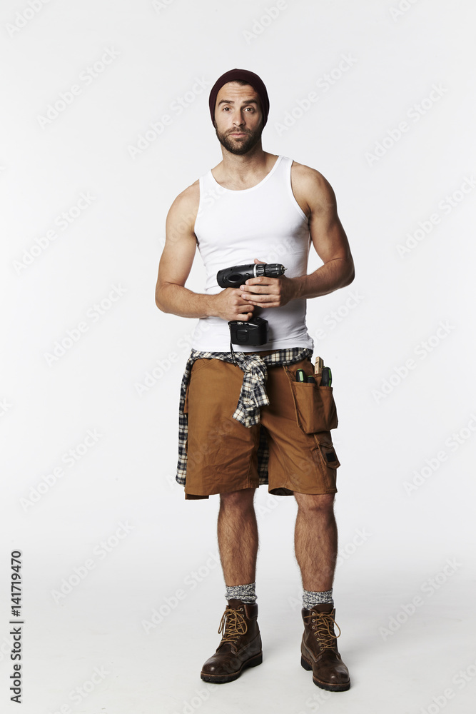 Portrait of worker holding drill in studio Portrait of worker holding drill in studio