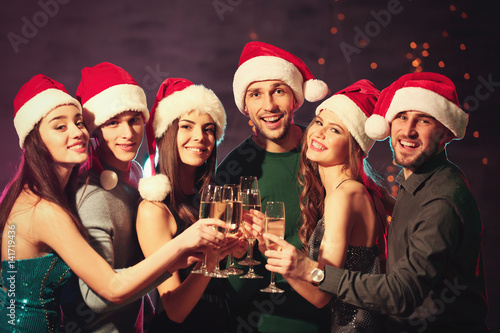 Friends clinking glasses at Christmas party in night club