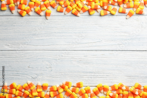 Colorful Halloween candy corns on wooden background
