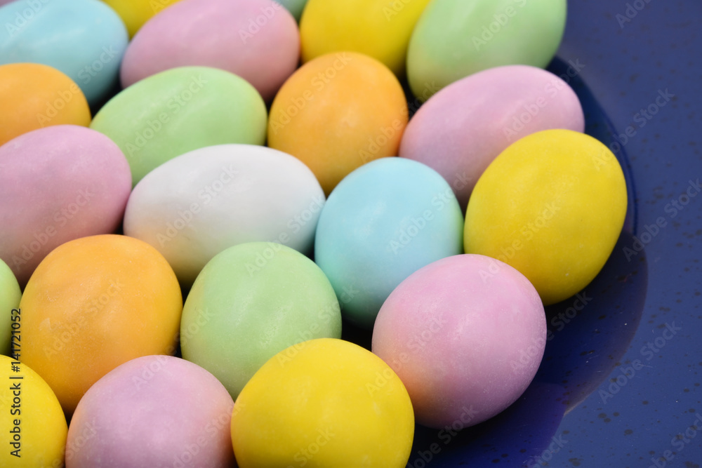 Close up of colorful Easter eggs of chocolate and sugar on a blue disc. Suitable to be used like a background. Close up of colorful Easter eggs of chocolate and sugar on a blue disc. Suitable to be used like a background.