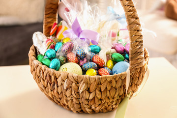 Beautiful Easter basket with traditional and sweets on table
