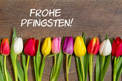 Tulpen auf Holzhintergrund: Frohe Pfingsten!