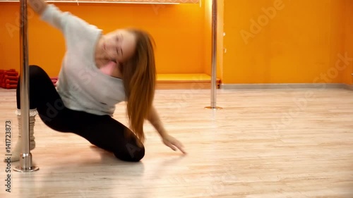 Young woman performing beautiful dence around the pole
