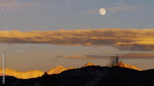 Amazing Full Moon Rising Above Mountain Range at Sunset photo