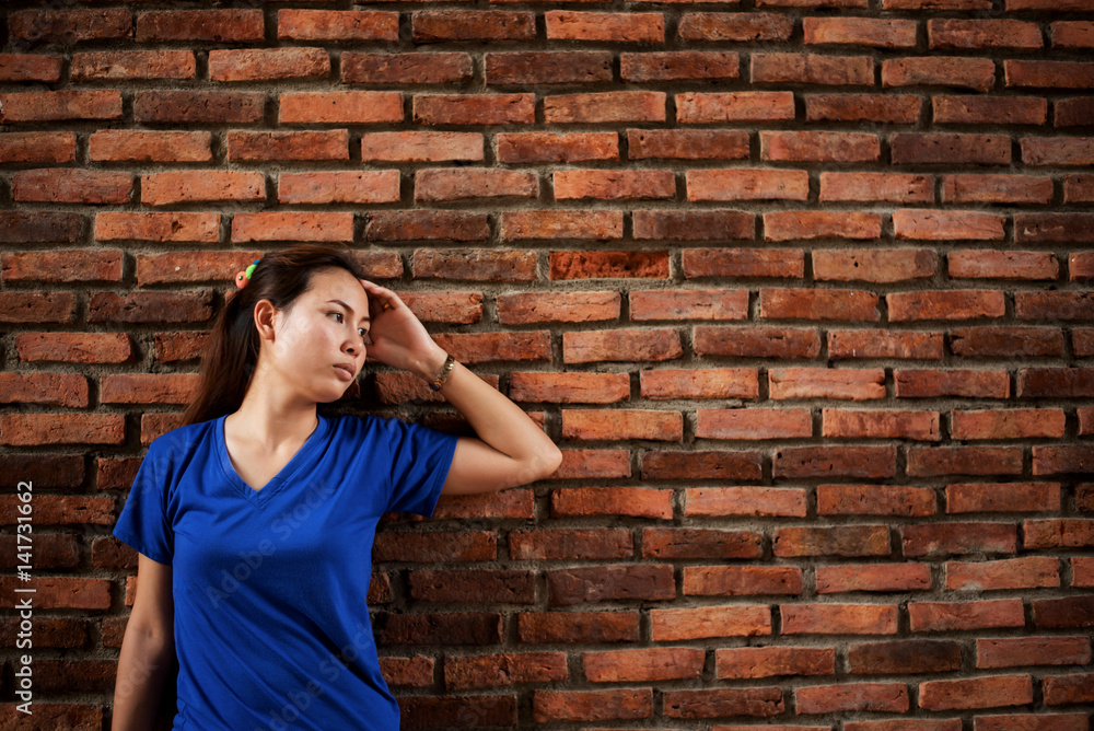 sad woman on the background of an old brick wall sad woman on the background of an old brick wall
