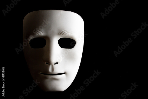 White human face mask on black background.