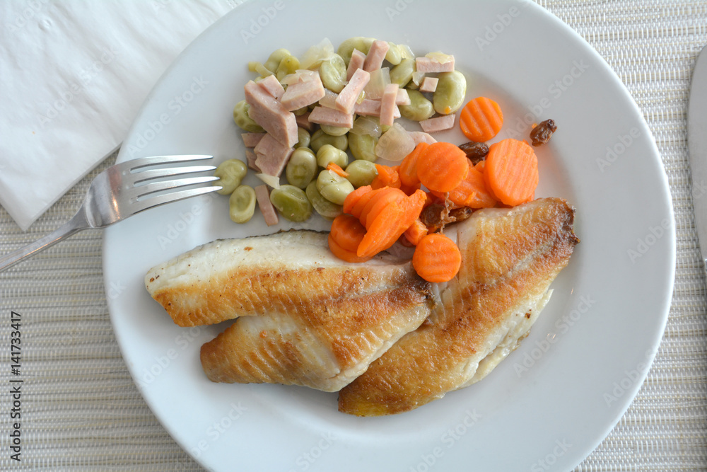 Grilled fish fillet with soybeans and ham on a white plate. Grilled fish fillet with soybeans and ham on a white plate.