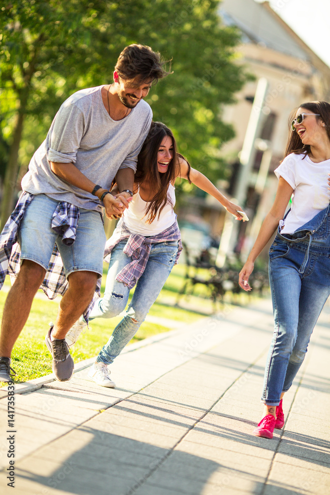 Fototapeta premium Group of happy young friends hangout and having fun at the city street.
