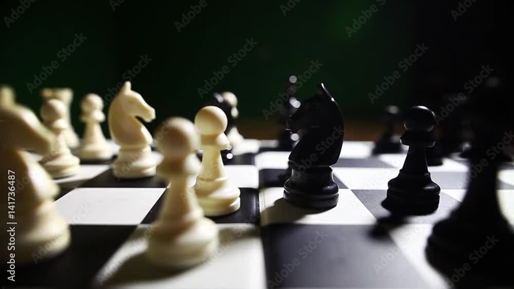 Dolly push shot of the white and black pieces on a chess board, with shallow depth of field. Dolly push shot of the white and black pieces on a chess board, with shallow depth of field.