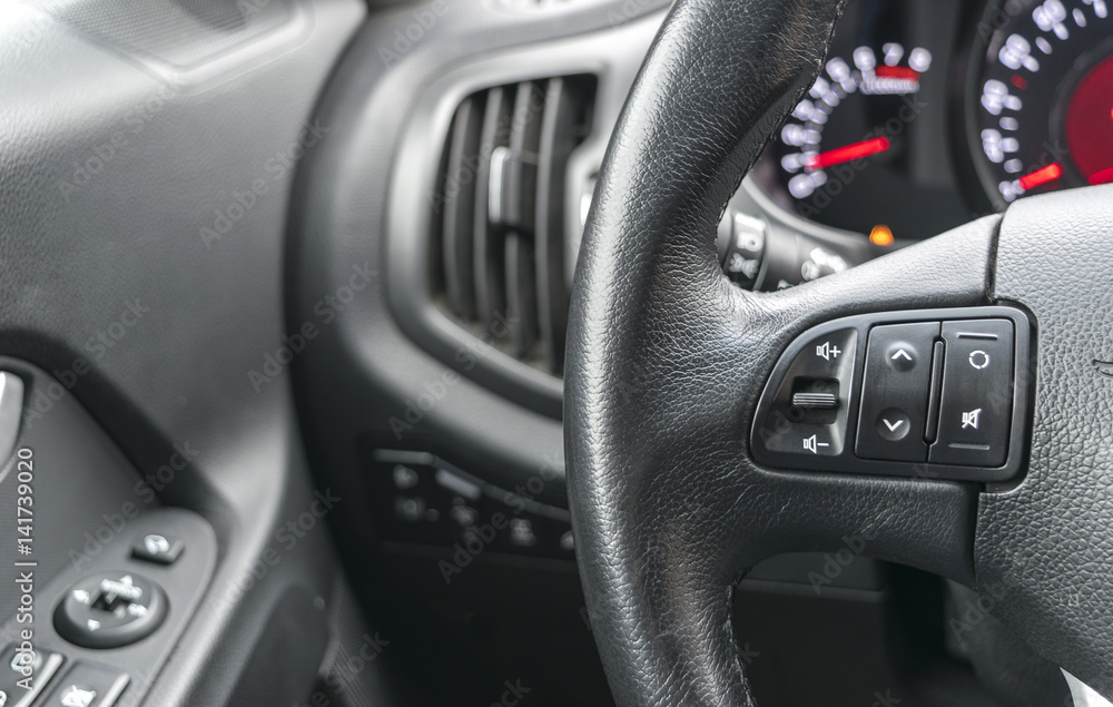 media control buttons on the steering wheel in black leather, modern car interior details