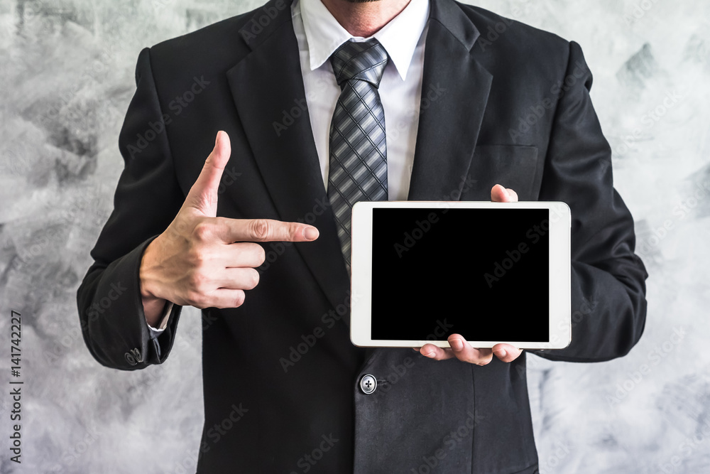 Close up of businessman holding tablet device on grunge background. Close up of businessman holding tablet device on grunge background.